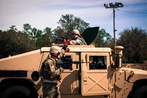 Staff Sgt. Thomas Maloney, of the 919th Security Forces Squadron, passes a weapon to an Airman in a HMMWV during an extraction exercise at Duke Field, Fla., April 6. The Security Forces Airmen executed this training exercise with the trainees from the Development and Training Program. The DTP is an Air Force Reserve Command introductory program to help recruits prepare for military life prior to going to basic military training. The trainees were given a first-hand view of the procedures performed to recover American personnel from a downed aircraft in a hostile environment. (U.S. Air Force photo/Tech. Sgt. Samuel King Jr.)