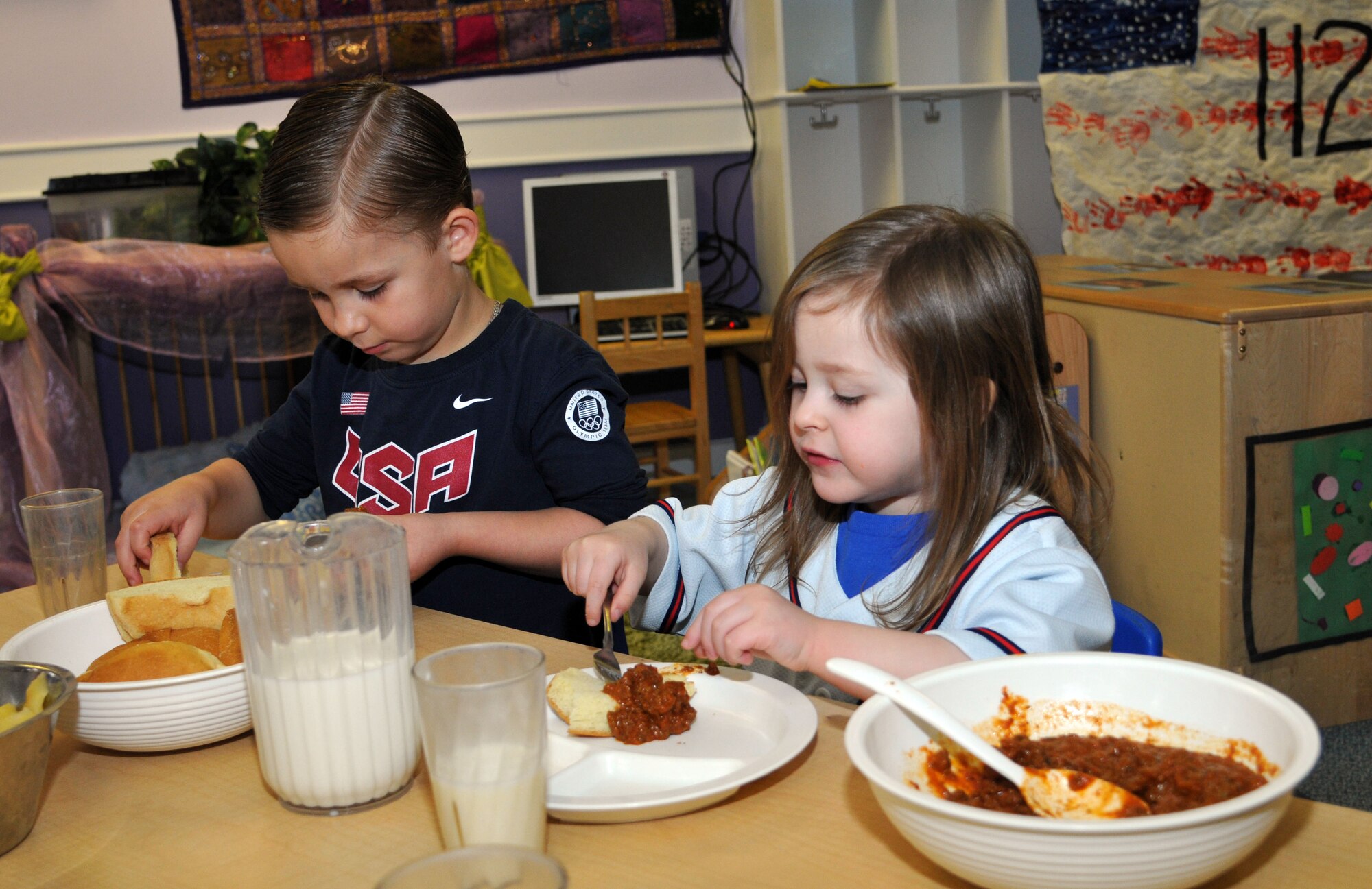 Dade Aponte, 4, son of Tech. Sgt. Michael Aponte,100th Operations Support Squadron air traffic control training and standardization NCO in charge, and Jayden Brede, 3, daughter of Tech. Sgt. Jason Brede, 373rd Training Squadron C-130 crew chief instructor, eat lunch April 11,2013,  while wearing red, white and blue, at the Child Development Center on RAF Mildenhall, England. The children at the CDC were encouraged to wear red, white and blue as part of spirit week during the Month of the Military Child. (U.S. Air Force photo by Airman 1st Class Kelsey Waters/Released)