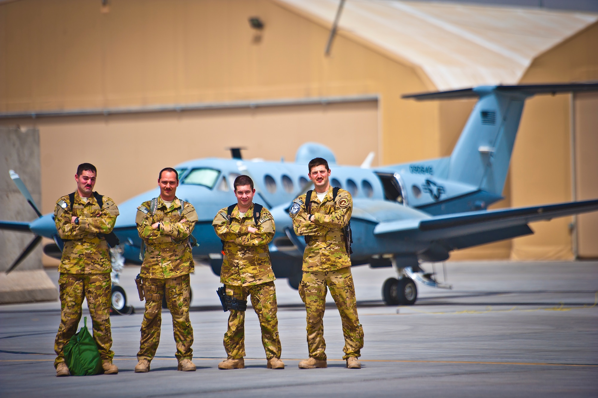 The crew of an MC-12 Liberty with the 361st Expeditionary Reconnaissance Squadron at Kandahar Airfield, Afghanistan, poses for a photo beside their jet on April 1, 2013. The crew flew a sortie that day surpassing the 100,000 flight-hour mark for the squadron in Afghanistan. The mission of the MC-12 is to provide intelligence, surveillance and reconnaissance support to ground forces. (U.S. Air Force photo/Senior Airman Scott Saldukas) 