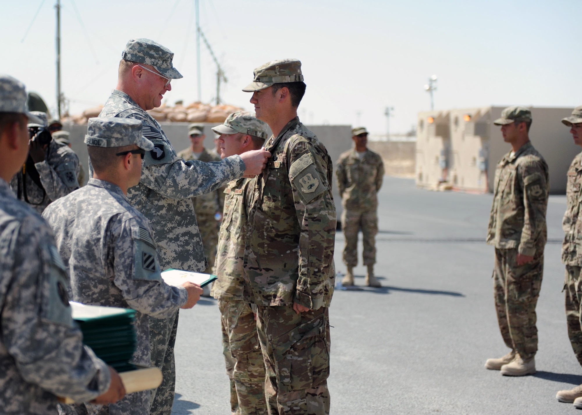 SOUTHWEST ASIA -  Army Col. Randall McIntire, 69th Air Defense Artillery Brigade commander, awards Air Force Capt. Ben Thomas, 557th ERHS construction site officer in charge, with an Army Commendation Medal for his team’s support of the 1-43 Air Defense Auxiliary Battalion, April 9. (U.S. Army photo/Capt. Steven Modugno)