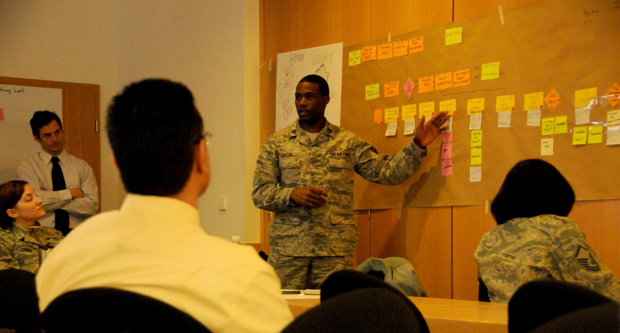Capt. Jason J. Carter, 86th Medical Squadron, briefs more than 50 students of the Air Force Smart Operations for the 21st Century Green Belt Process Improvement Class on how the equipment delivery process can be streamlined inside the 435th Construction Training Squadron Auditorium at Ramstein Air Base, Germany April 4, 2013. The class consisted of 55 students, the largest in Air Force history and focused on improving work center processes while removing waste or non-value added activities  U.S. Air Force Photo by Tech. Sgt. James M. Hodgman