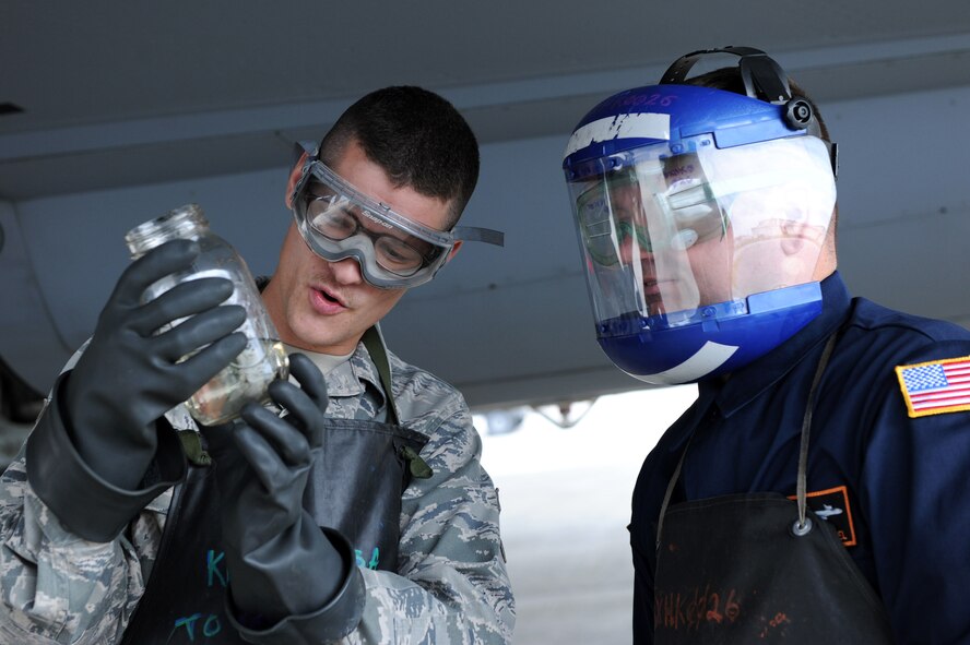 Airman 1st Class Trevor Naismith, 909th Aircraft Maintenance Unit crew chief, and U.S. Air Force Col. Brian McDaniel, 18th Wing vice commander, inspect fuel for contaminants on Kadena Air Base, Japan, April 11, 2013. Fuel must be tested for contaminants such as water and debris in order to keep contaminated fuel from mixing with non-contaminated fuel. (U.S. Air Force photo by Airman 1st Class Hailey R. Davis)