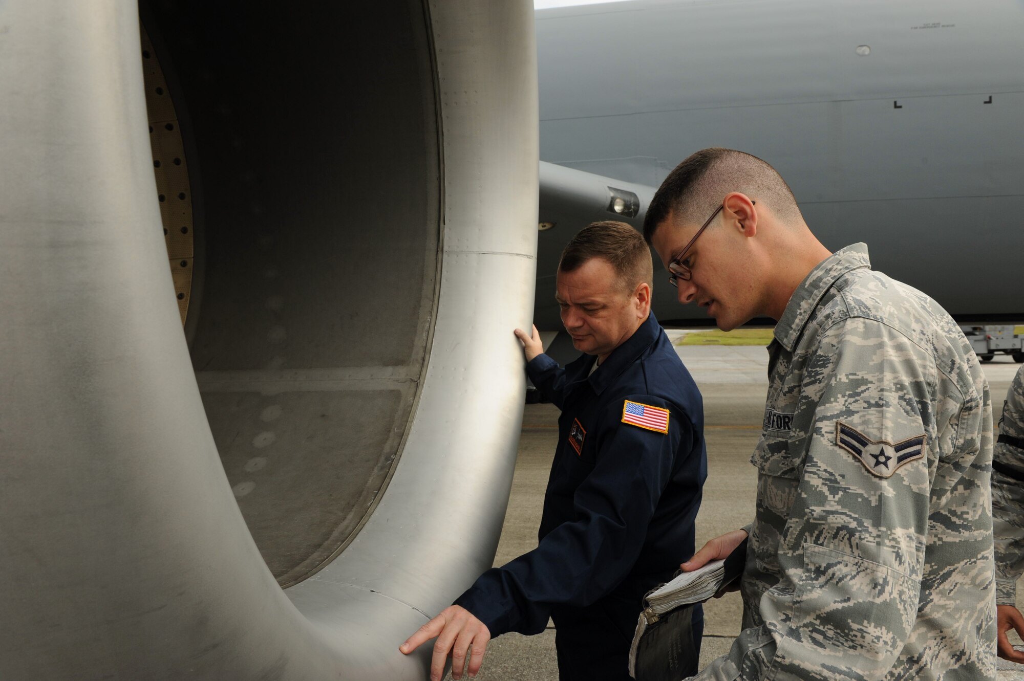 U.S. Air Force Col. Brian McDaniel, 18th Wing vice commander, and Airman 1st Class Trevor Naismith, 909th Aircraft Maintenance Unit crew chief, inspect the engine of a KC-135 Stratotanker on Kadena Air Base, Japan, April 11, 2013. Airmen from the 909th AMU taught McDaniel how aircraft maintenance is accomplished. (U.S. Air Force photo by Airman 1st Class Hailey R. Davis)