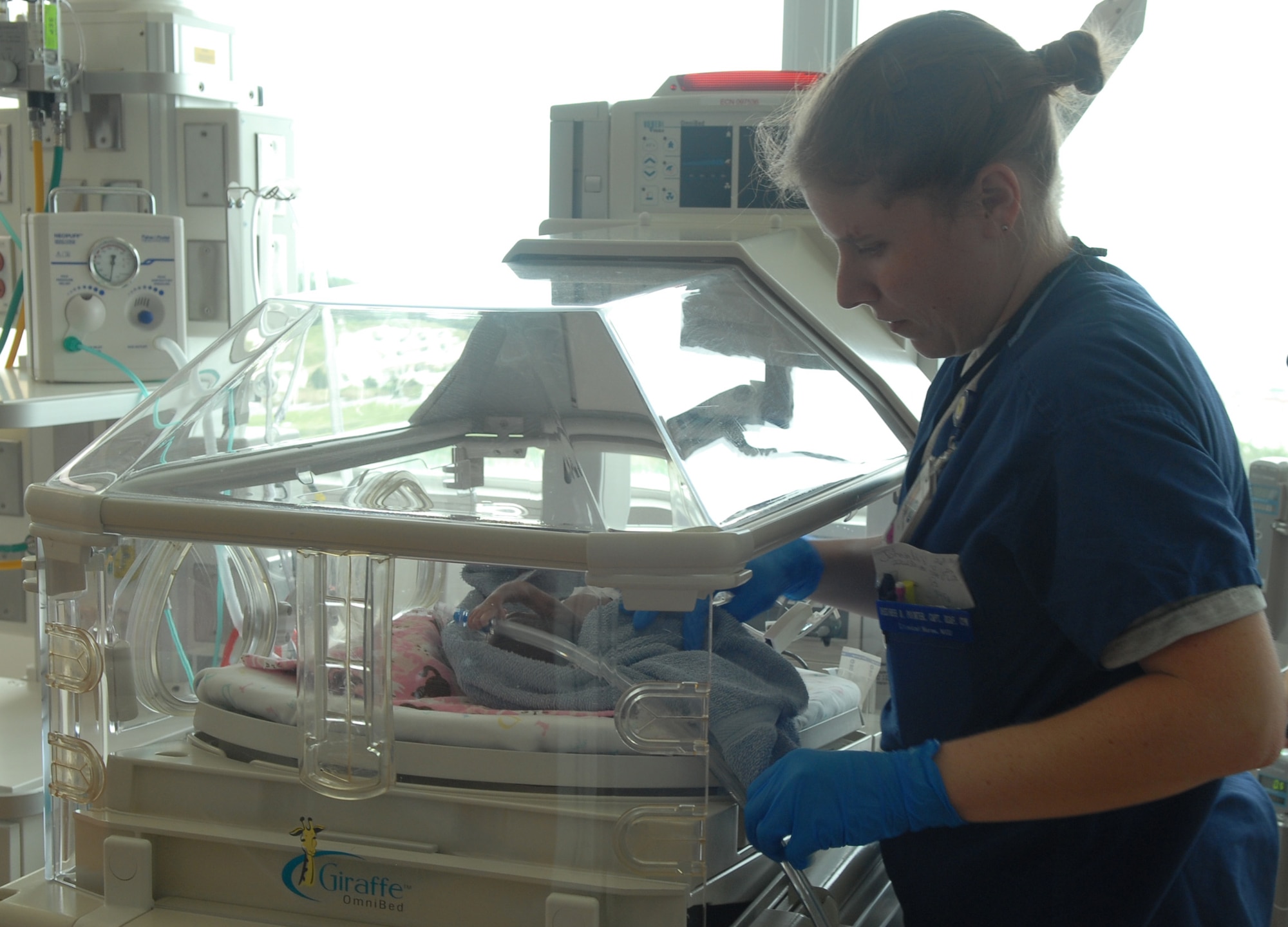 U.S. Air Force Capt. Desiree Pointer, of the 18th Medical Operations Squadron Neonatal Intensive Care Unit registered nurse, settles an infant into her newly prepared bed at Camp Foster, Japan, April 11, 2013.  The new NICU ward was able to expand to include two additional beds, all equipped with advanced ventilation systems addressing most premature babies' respiration needs. (U.S. Air Force photo by Staff Sgt. Lauren Snyder/Released)