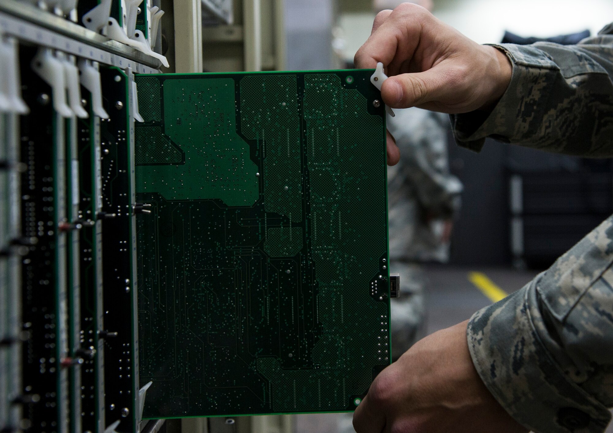 YOKOTA AIR BASE, Japan -- Airman 1st Class Colton Galloway, 374th Communications Squadron cyber transportation apprentice replaces a trunk card within the circuit site at Camp Zama, Japan, April 9, 2013. Circuit traffic from around the Pacific region is received by Zama's communications site and then pushed out to the world. (U.S. Air Force photo by Senior Airman Andrea Salazar/Released)