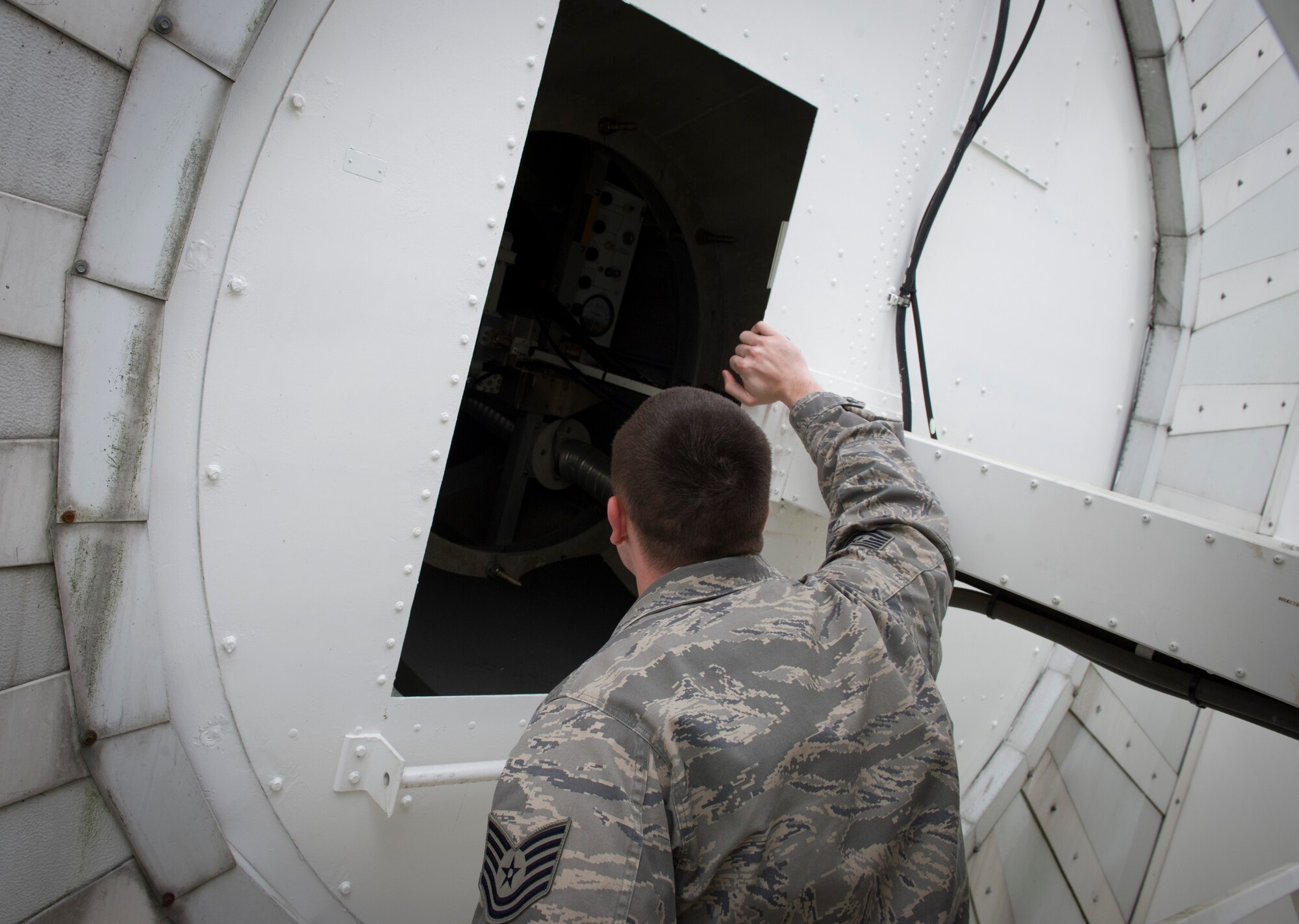 YOKOTA AIR BASE, Japan -- Tech. Sgt. Joshua Headrick, 374th Communications Squadron, operations crew chief, visually inspects inside a satellite at Camp Zama, Japan, April 9, 2013. Headrick checks for corrosion, dirt, properly working meters and identifies anything that may interrupt satellite transmission service. (U.S. Air Force photo by Senior Airman Andrea Salazar/Released)