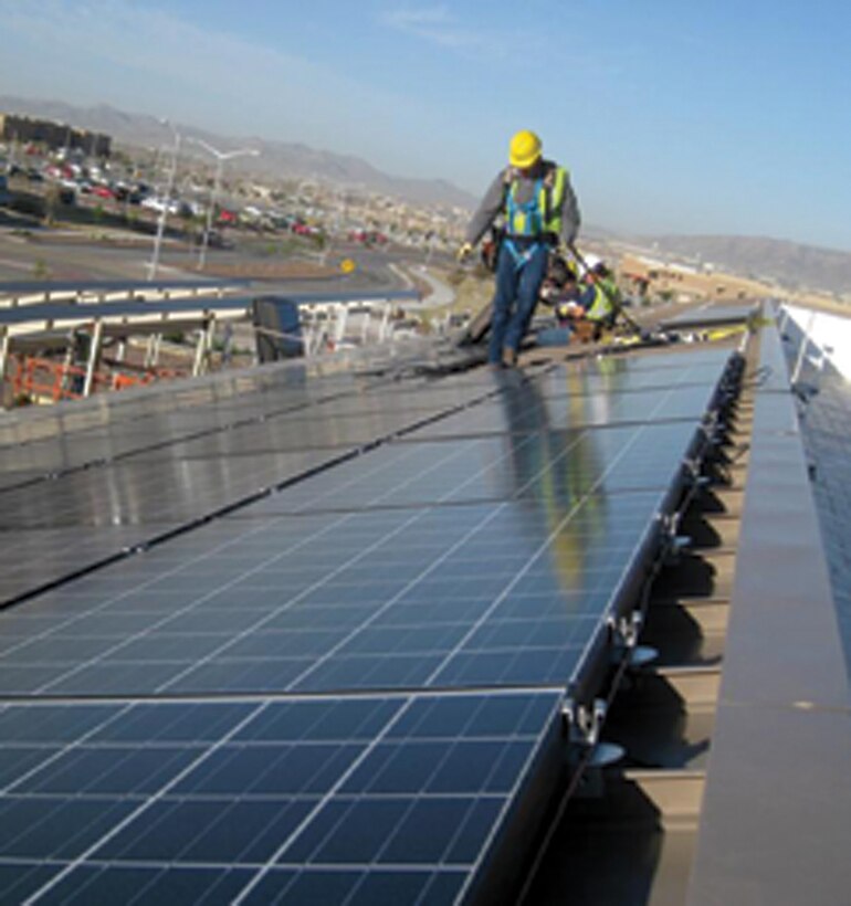 A contractor surveys his work atop a dining facility on Fort Bliss, Texas. Huntsville Center manages multiple types of projects on U.S. Army installations, like this facility-level solar project that was part of an Energy Savings Performance Contract. 