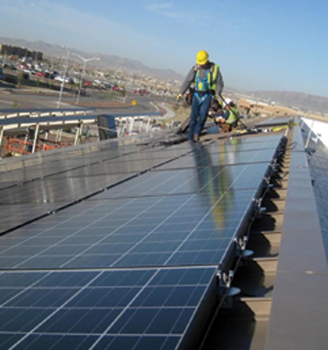 Fort Bliss, Texas: A contractor surveys his work atop a dining facility on Fort Bliss, Texas. Huntsville Center manages multiple types of projects on U.S. Army installations, like this facility-level solar project that was part of an Energy Savings Performance Contract. 