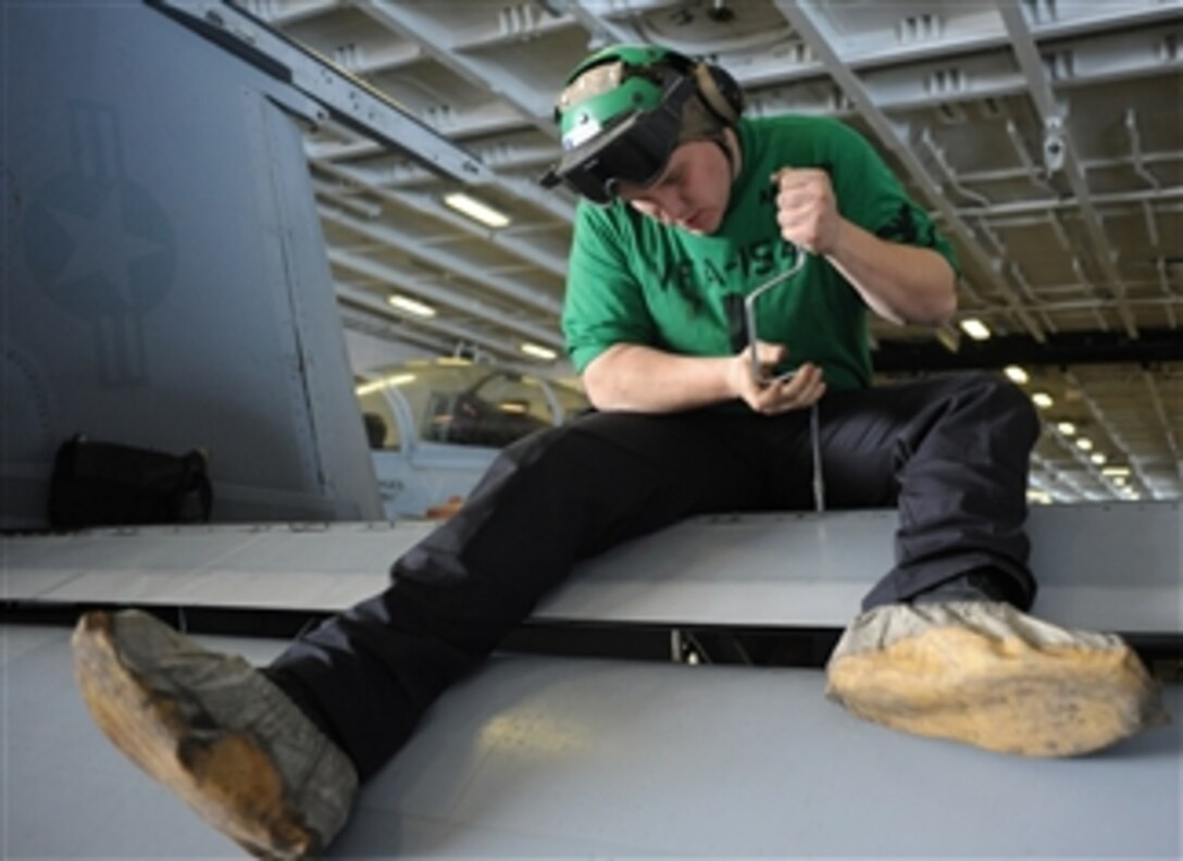 U.S. Navy Petty Officer 3rd Class Brady Miller works on the wing of an F/A-18F Super Hornet in the hangar bay of the aircraft carrier USS Nimitz (CVN 68) as the ship operates in the Pacific Ocean on April 10, 2013.  Miller is a Navy aviation structural mechanic assigned to Strike Fighter Squadron 154.  The Nimitz is underway to conduct sustainment-training exercises in preparation for an upcoming deployment.  