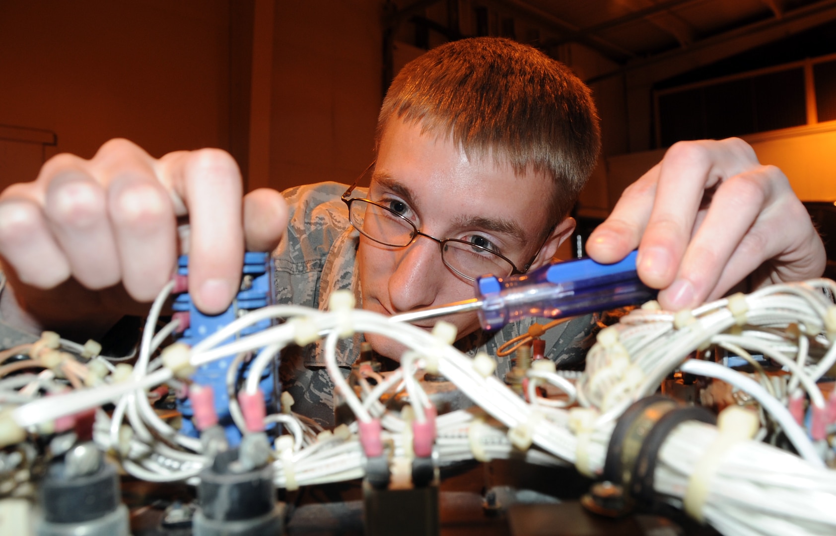 ALTUS AIR FORCE BASE, Okla. – Airman 1st Class Ross Honomichl, 97th Civil Engineer Squadron power production journeyman, checks a generator for faulty wires at the power production warehouse, April 12. Honomichl was inspecting for faulty wires thus ensuring the generator was mission qualified. Power production is responsible for maintaining all mission critical generators on base. (U.S. Air Force photo by Airman 1st Class Franklin R. Ramos / Released)