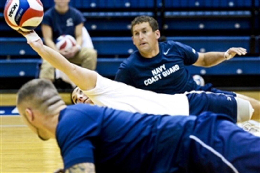 Navy Petty Officer 1st Class Linda Simpson, center, stretches to return a serve for the Navy's Warrior Games volleyball team during an exhibition game with the Penn State women's volleyball team in State College, Pa., April 5, 2013. Simpson is a mineman.