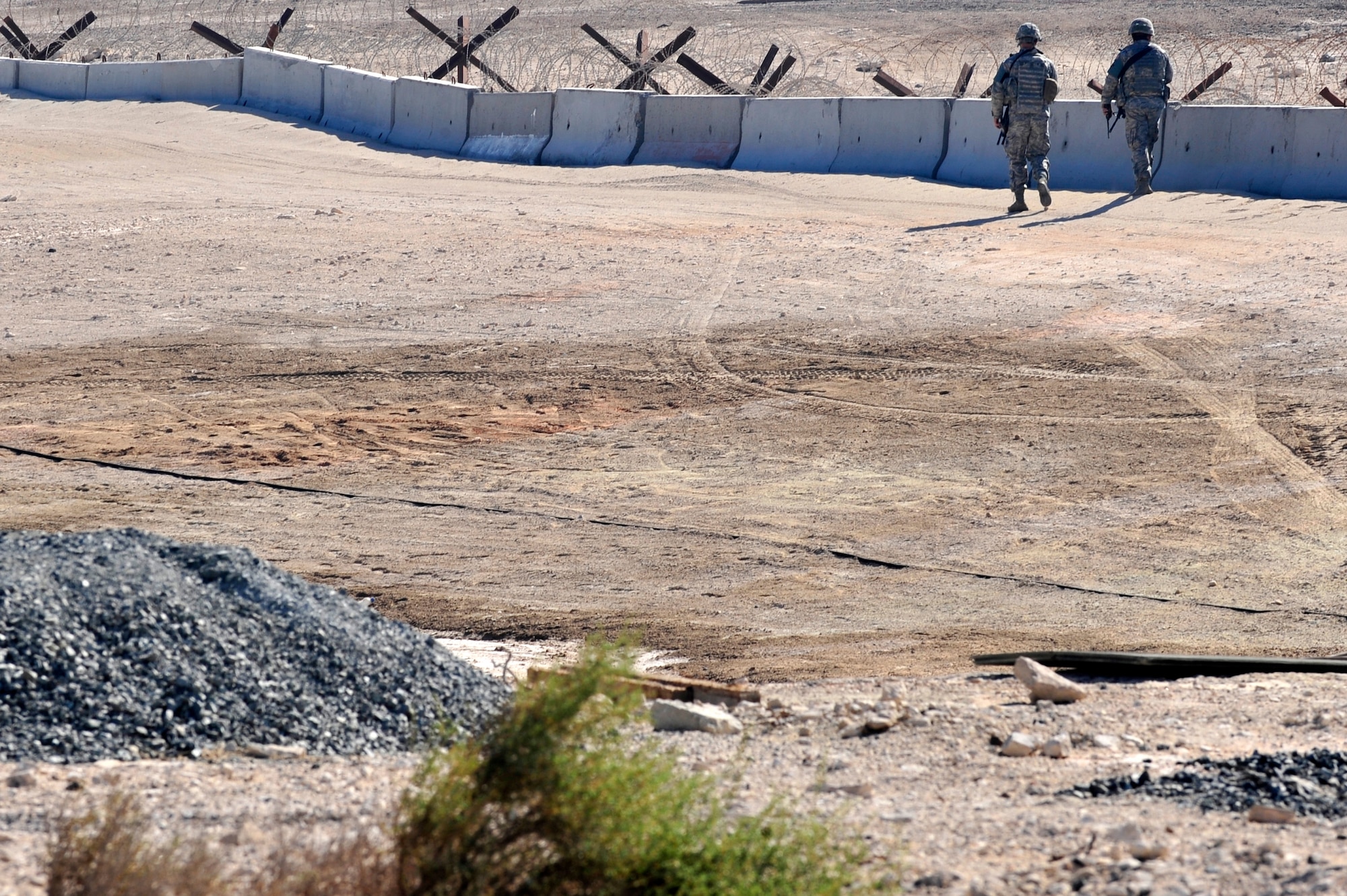 Patrolmen assigned to the 380th Expeditionary Security Forces Squadron perform a perimeter sweep during a base defense exercise at an undisclosed location in Southwest Asia Mar. 20, 2013. Tactical Automated Security System (TASS), installed at bases throughout the area of responsibility, alleviates the need for constant foot patrols performed by SFS personnel, which frees them to focus their attention on more vulnerable locations and increases the overall security of the installation.  (U.S. Air Force photo by Tech. Sgt. Christina M. Styer/Released)  