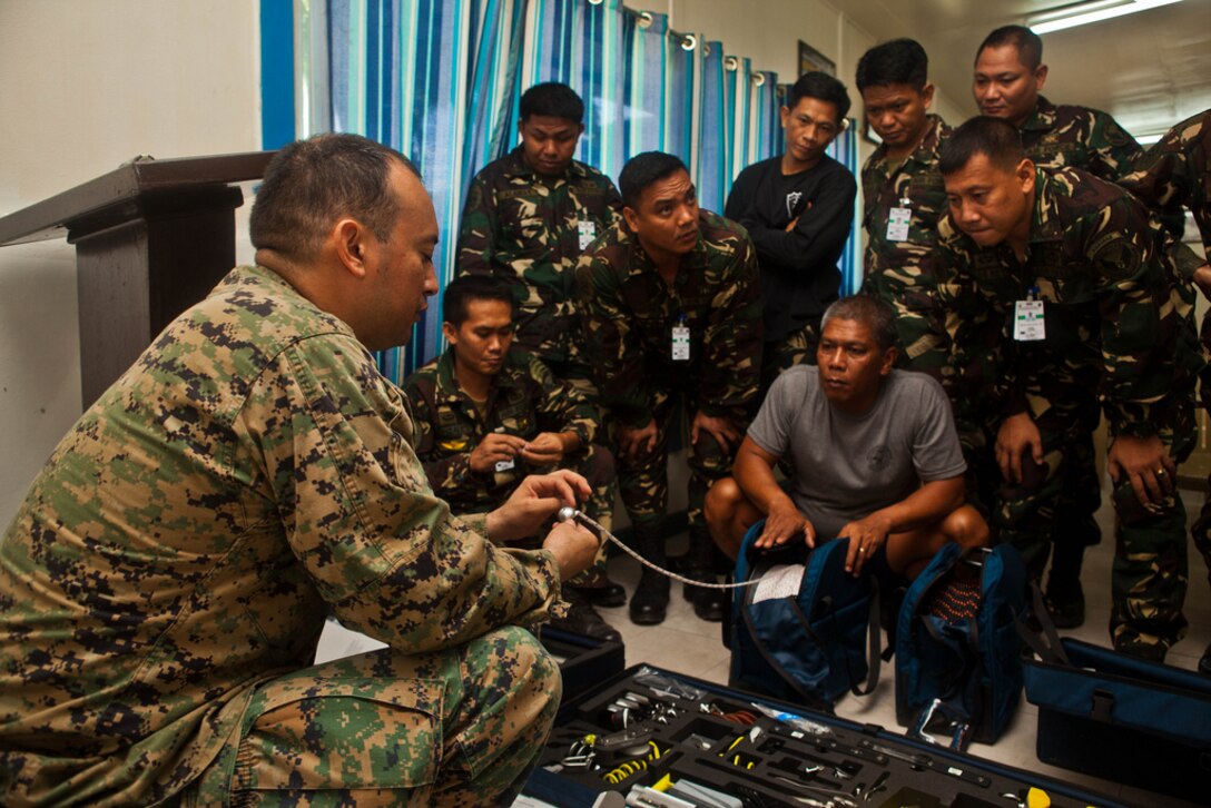 U.S. Marine Staff Sgt. Jose Acevedo explains the use of equipment from the HAL hook and line system, used for basic rigging and transporting, to Filipino explosive ordnance technicians at Clark Field, Republic of the Philippines, April 10. EOD technicians with the Philippine Air Force and the U.S. Marine Corps trained together during exercise Balikatan 2013, an annual bilateral exercise in its 29th iteration that is aimed at ensuring interoperability of the Philippine and U.S. militaries during planning, contingency and humanitarian assistance operations. Acevedo is an EOD technician with Marine Wing Support Squadron 172, 1st Marine Aircraft Wing, III Marine Expeditionary Force. 
