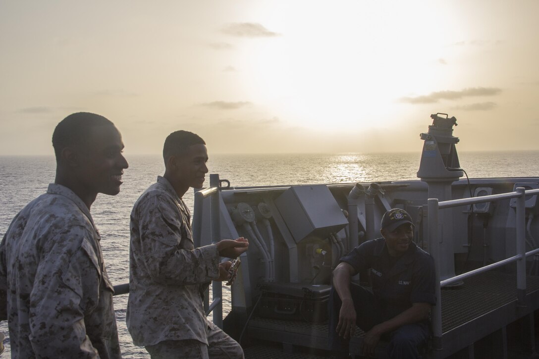 U.S. Marines and Sailors of the 26th Marine
Expeditionary Unit and USS Carter Hall (LSD 50) relax on the bridge wing aboard the ship while at sea April 14, 2013. The MEU is currently deployed as part of the Kearsarge Amphibious Ready Group to the 5th Fleet area of operation. The 26th MEU operates continuously across the globe, providing the president and unified combatant commanders with a forward-deployed,  sea-based quick reaction force. The MEU is a Marine Air-Ground Task Force capable of conducting amphibious operations, crisis response and limited contingency operations. 
(U.S. Marine Corps photo by Cpl. Michael S.
Lockett/Released)