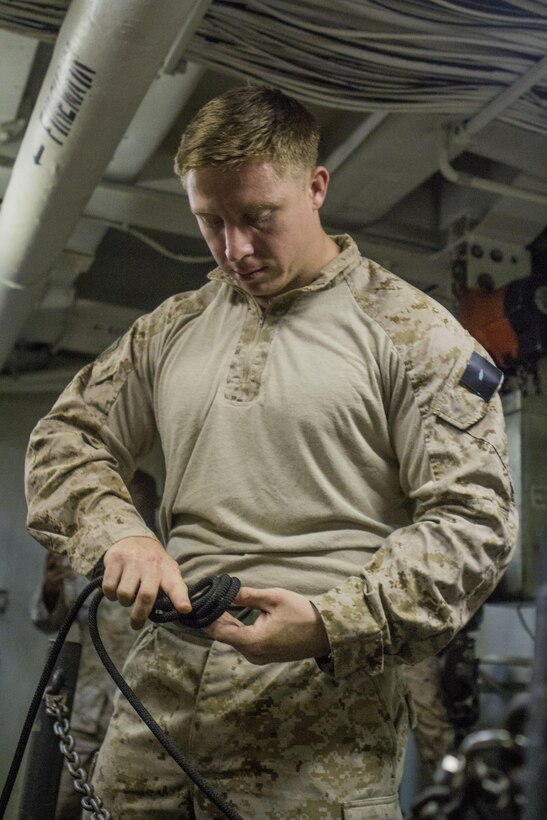 A U.S. Marine assigned to Battalion Landing Team 3/2, 26th Marine Expeditionary Unit (MEU), ties a rope before conducting fast rope and rappelling exercises aboard the USS Kearsarge (LHD 3) while at sea April 15, 2013. The 26th MEU is deployed to the 5th Fleet area of operations aboard the Kearsarge Amphibious Ready Group. The 26th MEU operates continuously across the globe, providing the president and unified combatant commanders with a forward-deployed, sea-based quick reaction force. The MEU is a Marine Air-Ground Task Force capable of conducting amphibious operations, crisis response and limited contingency operations. (U.S. Marine Corps photo by Cpl. Kyle N. Runnels/Released)