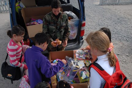 Master Sgt. Kelly Archambeault passes out toys to students here. She and other guardsmen from the 109th Airlift Wing helped organize toys to hand out to the kids. The toys were donated to Stratton Air National Guard Base in New York by Toys "R" Us.