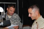 New Mexico Army National Guard chaplain Capt. Scott Brill and Navy Lt. Cmdr. Joseph Cubba read their script for the "Friends of God" radio show. Brill and Cubba have been doing the "Friends of God" radio program for two-months with positive feed back from the community.