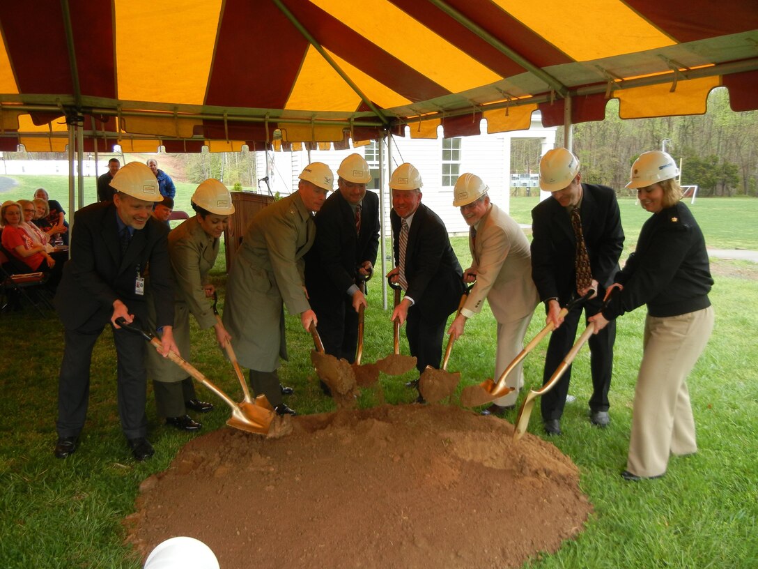 From left, Superintendent Michael Gould; Sgt. Maj. Laura Brown, the base sergeant major; Col. David Maxwell, the base commander; David Hughley, project manager with subcontractor Reynolds, Smith and Hills Inc.; Geoff Bambini, president of Homeland Contracting Corporation; Fred Bishop of Waller, Todd & Sadler Architects; Kirk Nelson, head of the base Installation and Environment Division; and Lt. Cmdr. Julie Meier, Quantico’s resident officer in charge of construction, scoop the first shovel-fulls of earth from the site of the elementary school that is about to be built near Quantico Middle/High School on April 12, 2013. 