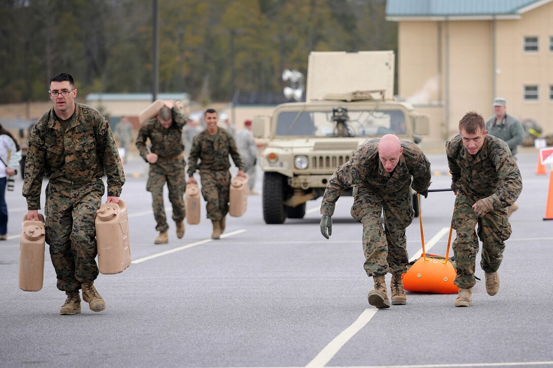 USMC Recon team, perform SKEDCO PULL during the Disciplus Validus
(extreme physical training test) competition at Fort Benning, Georgia.The
Army¹s top Calvary Scouts competed in the inaugural Gainey Cup
competition at Fort Benning, Ga., March 1-5. The five-day event tested 20
five-man teams on Calvary Scout skills such as day and night fires,
weapons familiarization, area reconnaissance, and observation post
establishment. It also tested their physical endurance with multi-phased
road marches, obstacle courses and a multi-event physical fitness test
that included not only the standard push-ups and sit-ups but also pull
ups, dips, bench press, rope climb, tire flip, and pushing a HUMVEE up an
incline.