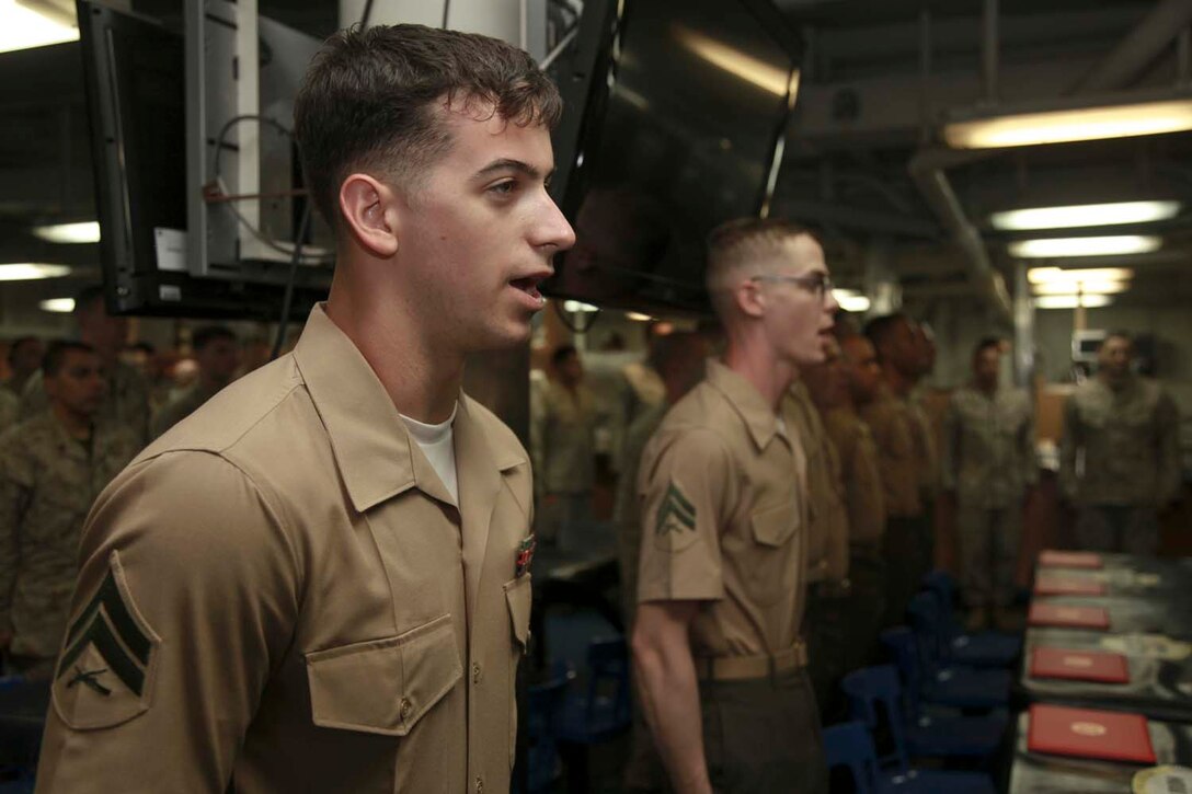 USS PELELIU (April 5, 2013) Corporal James E. Stires, unit movement control coordinator, Command Element, 15th Marine Expeditionary Unit, sings the Marine Corps hymn with the Corporals of Corporals’ Course 338-13 on the mess decks of USS Peleliu, April 5. Corporals’ Course is a professional military education for enlisted Marines designed to give corporals the tools to become more effective small unit leaders. The 15th MEU is comprised of approximately 2,400 Marines and sailors and is deployed as part of the Peleliu Amphibious Ready Group. Together, they provide a forward-deployed, flexible sea-based Marine Air Ground Task Force capable of conducting a wide variety of operations ranging from humanitarian aid to combat. Stires, 21, is from Wichita Falls, Texas. (U.S. Marine Corps photo by Cpl. John Robbart III/Released)