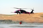 An HH-60G Pave Hawk from the 129th Rescue Wing, California Air National Guard, hovers over a pond near Sacramento, Calif. July 2. The aircrews were training with water buckets, becoming the only crews certified for firefighting suppression duty in the U.S. Air Force and Air National Guard.