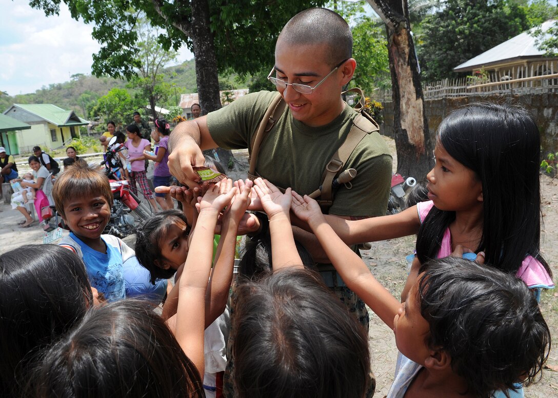 U.S. Marine Lance Cpl. Joe Salinas, a San Antonio native and engineer with 9th Engineer Supply Battalion, 3rd Marine Logistics Group, III Marine Expeditionary Force, hands out candy to a group of Filipino children at Maruglo Elementary School in Crow Valley, Philippines, April 12 during ongoing community relations events at Balikatan 2013, an annual Philippine-U.S. bilateral exercise. Humanitarian assistance and training activities enable the Philippine and U.S. forces to build lasting relationships, train together and provide assistance in communities where the need is the greatest.