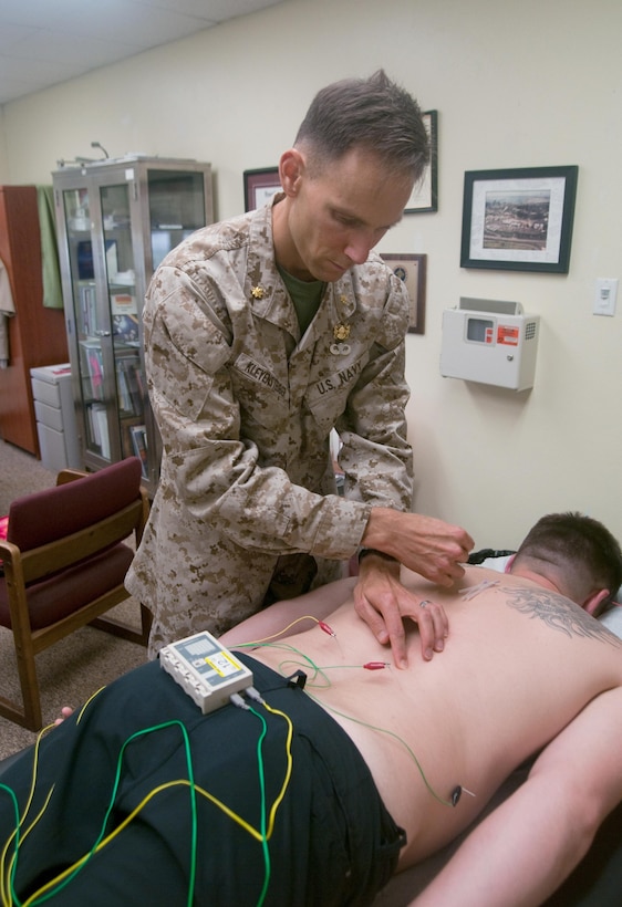 MARINE CORPS BASE HAWAII — Lt. Cmdr. Brian Kleyensteuber, a Navy psychiatrist embedded with 3rd Marine Regiment, uses low pulse electricity with acupuncture needles on Sgt. Kevin Ivey, a rifleman with 3rd Marine Regiment. Kleyensteuber provides infantry and artillery Marines with free mental health care through the Operational Stress Control and Readiness program. (U.S. Marine Corps photo by Christine Cabalo)