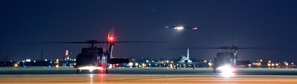 Black Hawk helicopters from the Texas Army National Guard wait with their engines running as the C-17 Globemaster III aircraft carrying three former hostages approaches Lackland Air Force Base, Texas, July 2, 2008. Three U.S. government contractors were rescued today by Colombian security forces after being held captive by the Revolutionary Armed Forces of Columbia, or FARC, since their plane crashed in a remote area in February 2003. The aircraft is stationed at Travis Air Force Base, Calif.