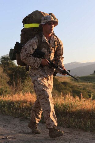 Lance Cpl. Kelly Deutsch, a rifleman serving with Fox Company, 2nd Battalion, 1st Marine Regiment, and a native of San Diego, hikes an 11-mile route with a full combat load to the companyÕs next training destination here, April 2, 2013. The hike began at 6:30 a.m. and finished approximately four hours later. The company conducts hikes weekly to build strength, confidence and unit-readiness. Hikes also give small-unit leaders an opportunity to lead Marines and build camaraderie.