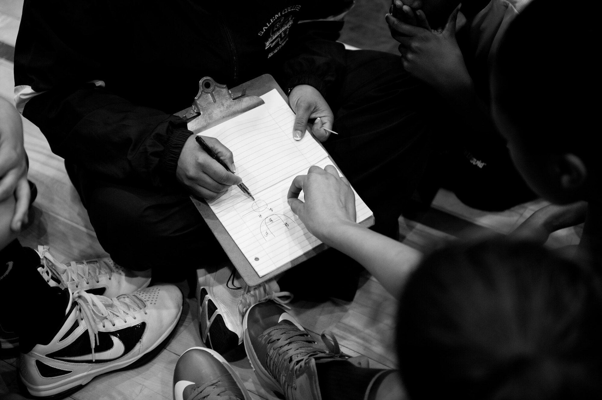 Athletes review game strategy and play layouts during the Women’s All Star Game at the Mainland Basketball Camp at Yokota Air Base, Japan, April 12, 2013. A combined All-Star game of the camps best players followed the women’s game. (U.S. Air Force photo by Senior Airman Cody H. Ramirez/Released)