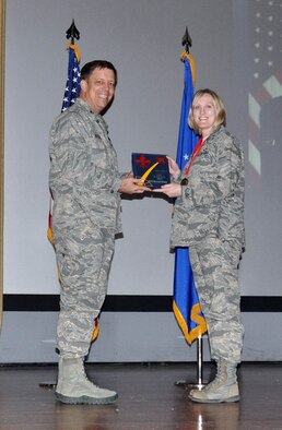 NELLIS AIR FORCE BASE, Nev. -- (Right) Lt. Melanie Singer, 706th Fighter Squadron receives the award for 926th Group Company Grade Officer of the Year from Col. John Breeden, 926th Group commander, here April 6. Singer was also named Air Force Reserve Command's Information Dominance Professional CGO of the Year. Integrated into the Regular Air Force's 99th Communications Squadron here, Singer led its largest flight where she oversaw the operation and maintenance of millions of dollars in Air Force information technology assets. Her team supported multiple exercises, 14,000 network users, the Federal Aviation Administration and a NASA shuttle mission. (U.S. Air Force photo/Maj. Jessica Martin)