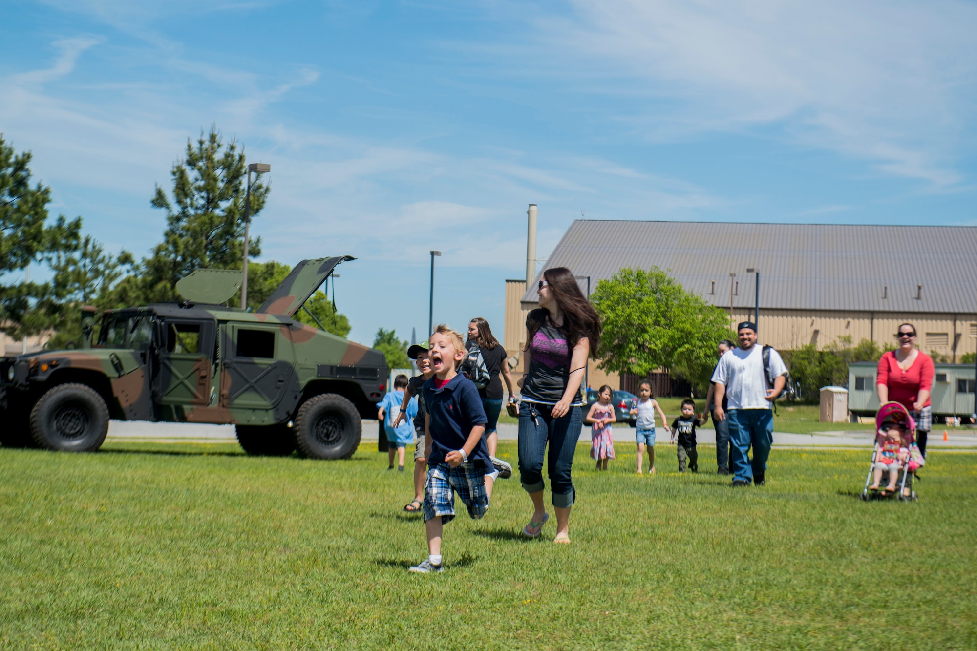 Children and families roam the Freedom I Fitness Center field during a Kids Deployment Line April 13, 2013, at Moody Air Force Base, Ga. The field held various stations were children could take part in different activities and operate equipment. (U.S. Air Force photo by Staff Sgt. Jamal D. Sutter/Released) 