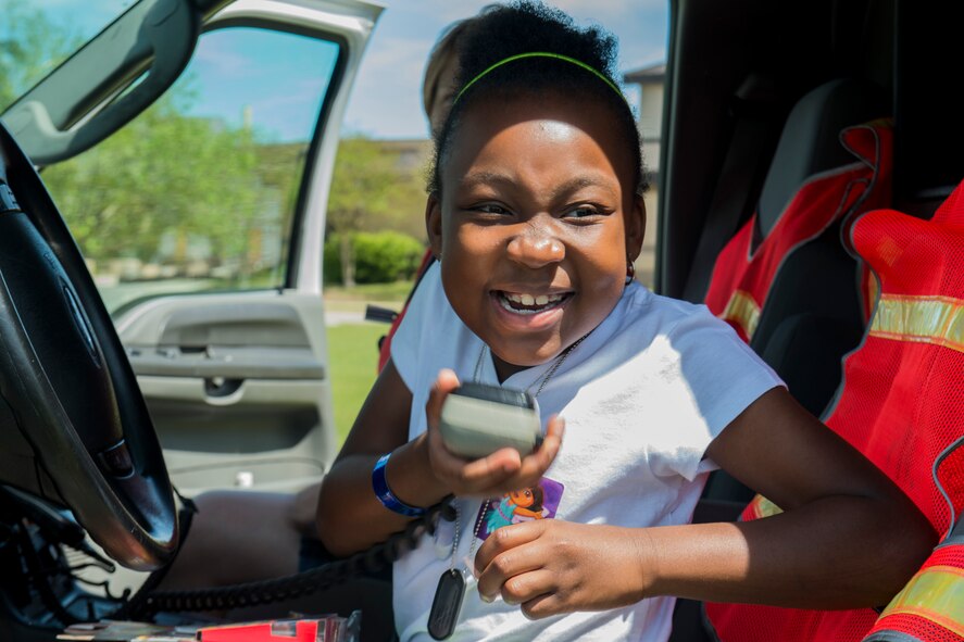 Kyra Pollard, daughter of U.S. Air Force Tech. Sgt. Tiffany Buford, 23d Force Support Squadron, operates an ambulance public address system during a Kids Deployment Line April 13, 2013, at Moody Air Force Base, Ga. The event gave kids a chance to experience some of the things their parents go through prior to and during deployments. (U.S. Air Force photo by Staff Sgt. Jamal D. Sutter/Released)