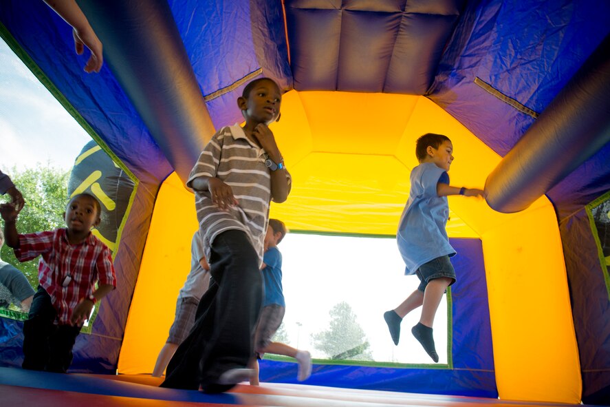 Kids play in a bounce house during a Kids Deployment Line April 13, 2013, at Moody Air Force Base, Ga. Many activities including obstacle courses and a working dog demonstration were available for children to take part of. (U.S. Air Force photo by Staff Sgt. Jamal D. Sutter/Released) 
