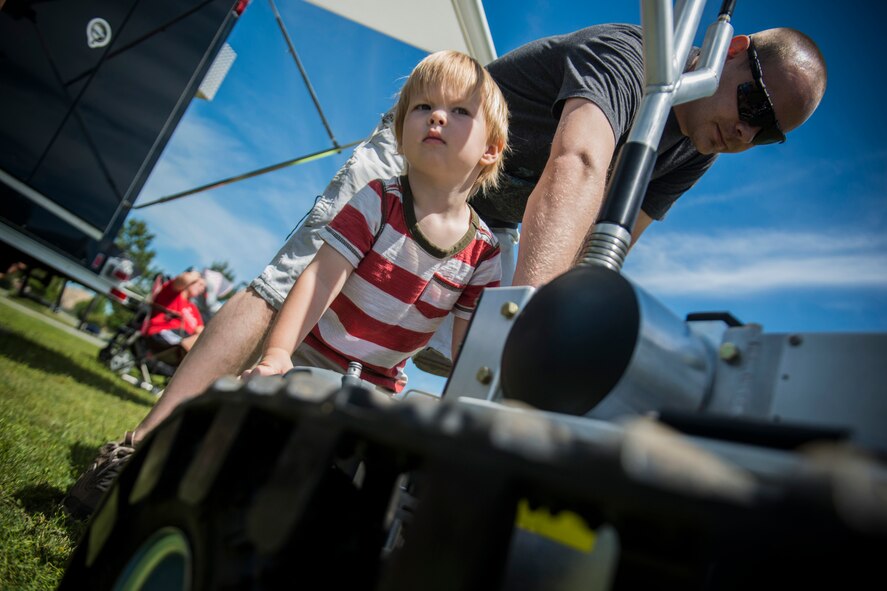 Colton Stewart, son of U.S. Air Force Airman 1st Class Christopher Stewart, 823d Base Defense Squadron, operates an explosive ordnance disposal robot with assistance from Staff Sgt. Ryan Prince, 23d Civil Engineer Squadron EOD technician, during a Kids Deployment Line April 13, 2013, at Moody Air Force Base, Ga. The event gave kids a chance to experience various jobs that make up the Moody mission. (U.S. Air Force photo by Staff Sgt. Jamal D. Sutter/Released)  