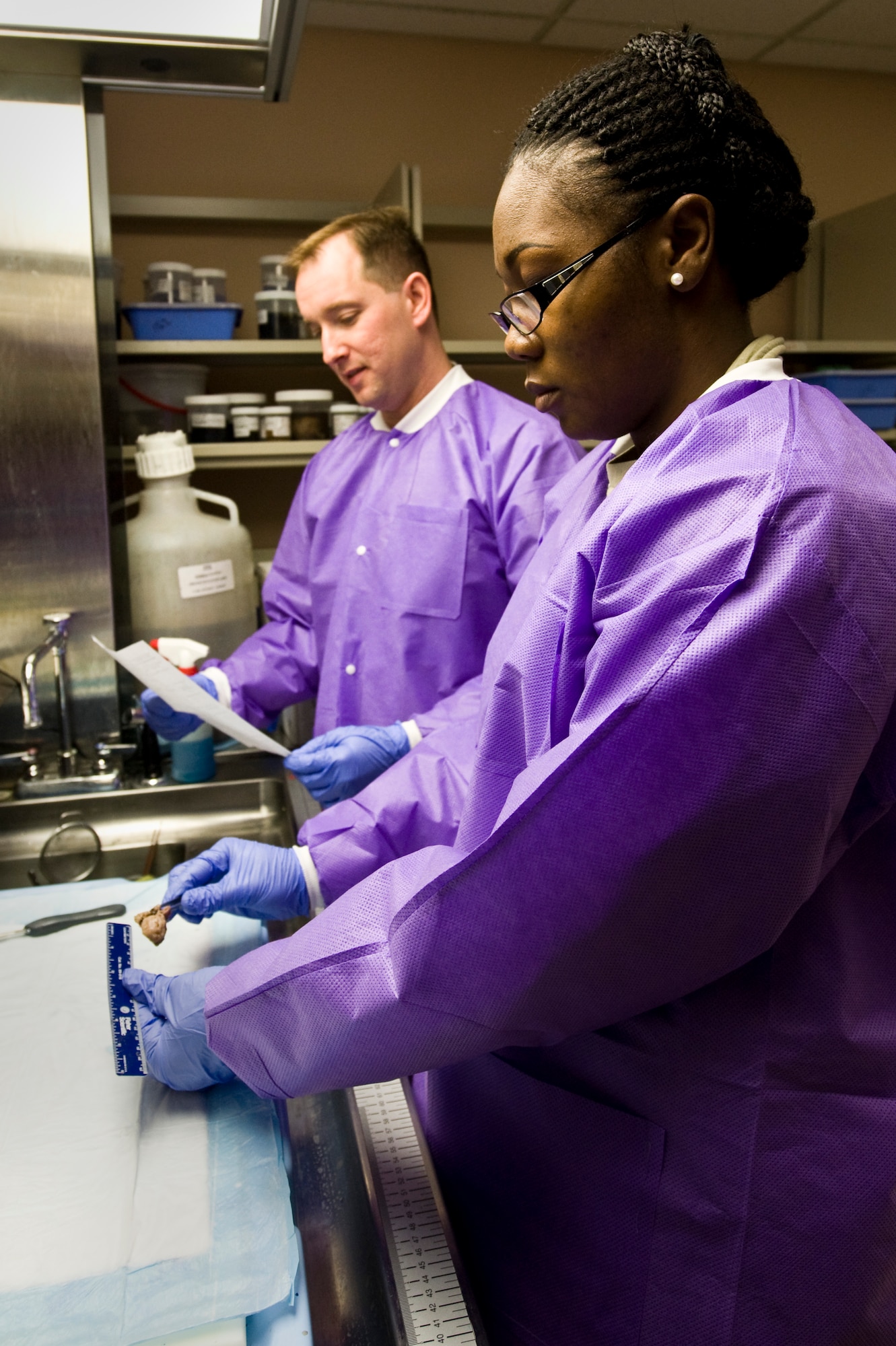 Staff Sgt. Onyee Carter, 99th Medical Support Squadron histology technician, measures a tonsil as Maj. (Dr.) Bradley Lachey, 99th Medical Support Squadron pathologist, advises her on patient information April 10, 2013, at Nellis Air Force Base, Nev. Histology is the study of microscopic anatomy of cells and tissues of plants and animals.  It is commonly performed by examining cells and tissues by sectioning and staining followed by examination under a light microscope or electron microscope. (U.S. Air Force photo by Airman 1st Class Jason Couillard)