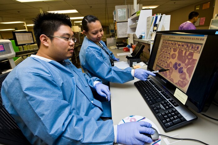 Adam Wen and Senior Airman Aleza Chan, 99th Medical Support Squadron hematology technicians, analyze pictures of white blood cells April 10, 2013, at Nellis Air Force Base, Nev. The photos of white blood cells are analyzed to check for any abnormalities that may be present. Abnormalities in white blood cells can indicate different types of diseases. (U.S. Air Force Photo by Airman 1st Class Jason Couillard)