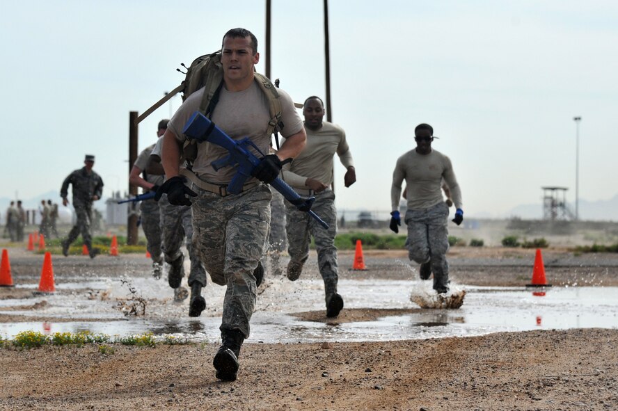 1st Lt. Anthony Hylco, 56th CES Programs Flight deputy, runs with his team through water April 4 during the Prime BEEF challenge held at the ATSO area. (U.S. Air Force photo/Senior Airman Sandra Welch)