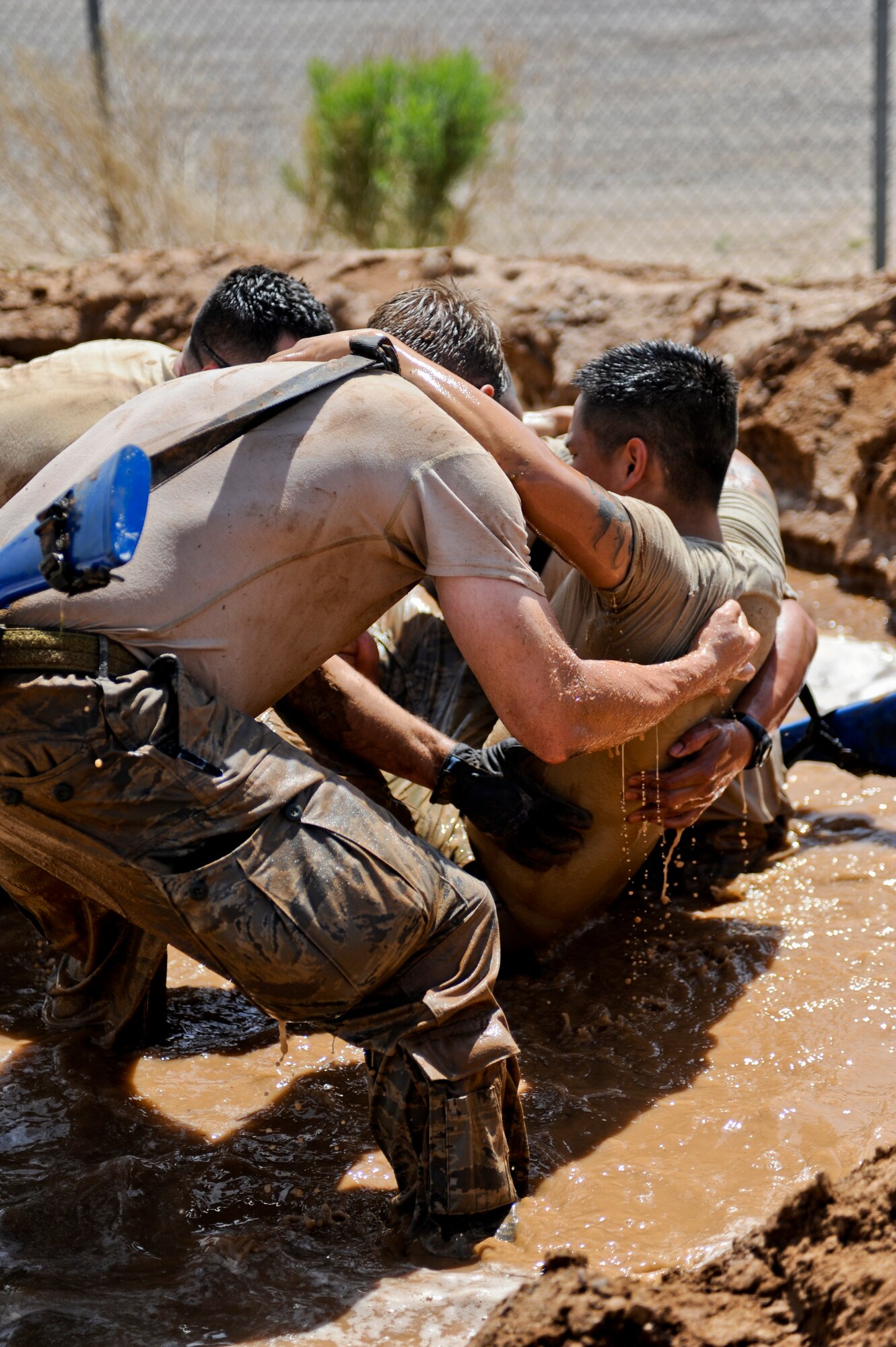 Members assist a wingman with a simulated injury during the Prime BEEF Challenge. The teams performed three carries through a pit filled with mud and water – a single-man, two-man and a litter. (U.S. Air Force photo/Staff Sgt. C.J. Hatch)