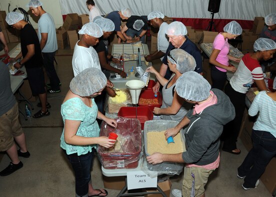 Luke Air Force Base volunteers worked Saturday to package meals to send to Afghanistan to feed hungry children. The food is provided by Food for Kidz and the packages are a mixture of rice, soy flour, dehydrated vegetables, vegan protein powder and spices which are sealed in industrial-grade plastic bags and have a shelf life of seven years. (U.S. Air Force photo/Tech. Sgt. Louis Vega Jr.)