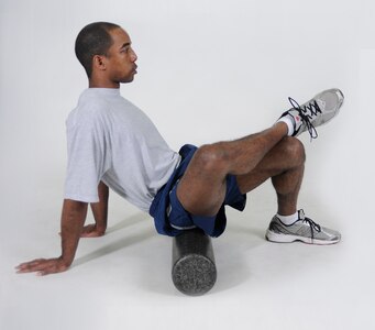 Glutes Foam Roll
Sit on a foam roller with it positioned on the right glute. Cross the right leg over the front of the left thigh and put hands on the floor for support. Roll the body forward and backward in small movements from the lower glute to the upper glute. Repeat with the roller under the left glute.
