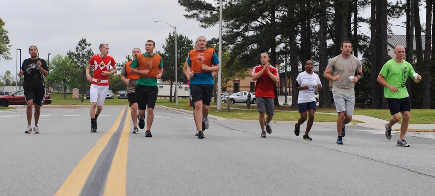 Members of Team Moody run the final stretch of road to reach the end of a Warrior 5K race April 12, 2013, at Moody Air Force Base, Ga. After finishing, a few runners returned to the trail to help motivate the remaining participants. (U.S. Air Force photo by Airman Alexis Grotz/Released)