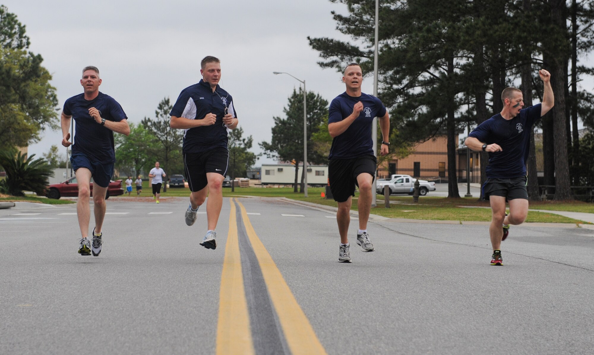 A group of first sergeants celebrate as they race to the finish line during a Warrior 5K race April 12, 2013, at Moody Air Force Base, Ga. Airmen stood on the sidelines to cheer them on as they finished the race. (U.S. Air Force photo by Airman Alexis Grotz/Released)