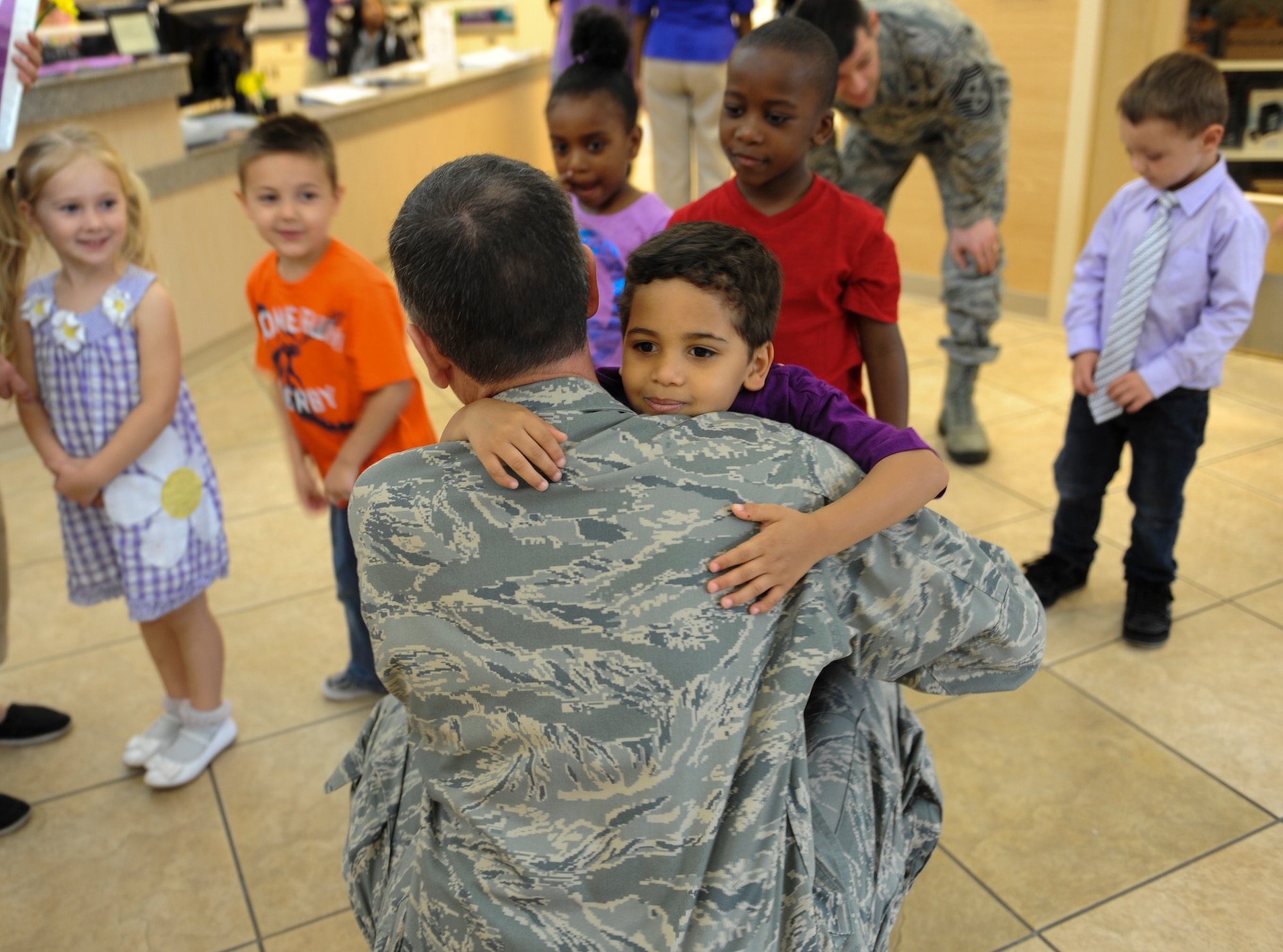 Jantin Wykoff, son of U.S. Air Force Airman 1st Class Nicholes Wykoff, 723d Aircraft Maintenance Squadron aerospace propulsion apprentice, hugs Col. Billy Thompson, 23d Wing commander, at the Child Development Center April 12, 2013, at Moody Air Force Base, Ga. Jantin and classmates watched as Thompson signed a volunteer appreciation proclamation. (U.S. Air Force photo by Airman Alexis Grotz/Released)
