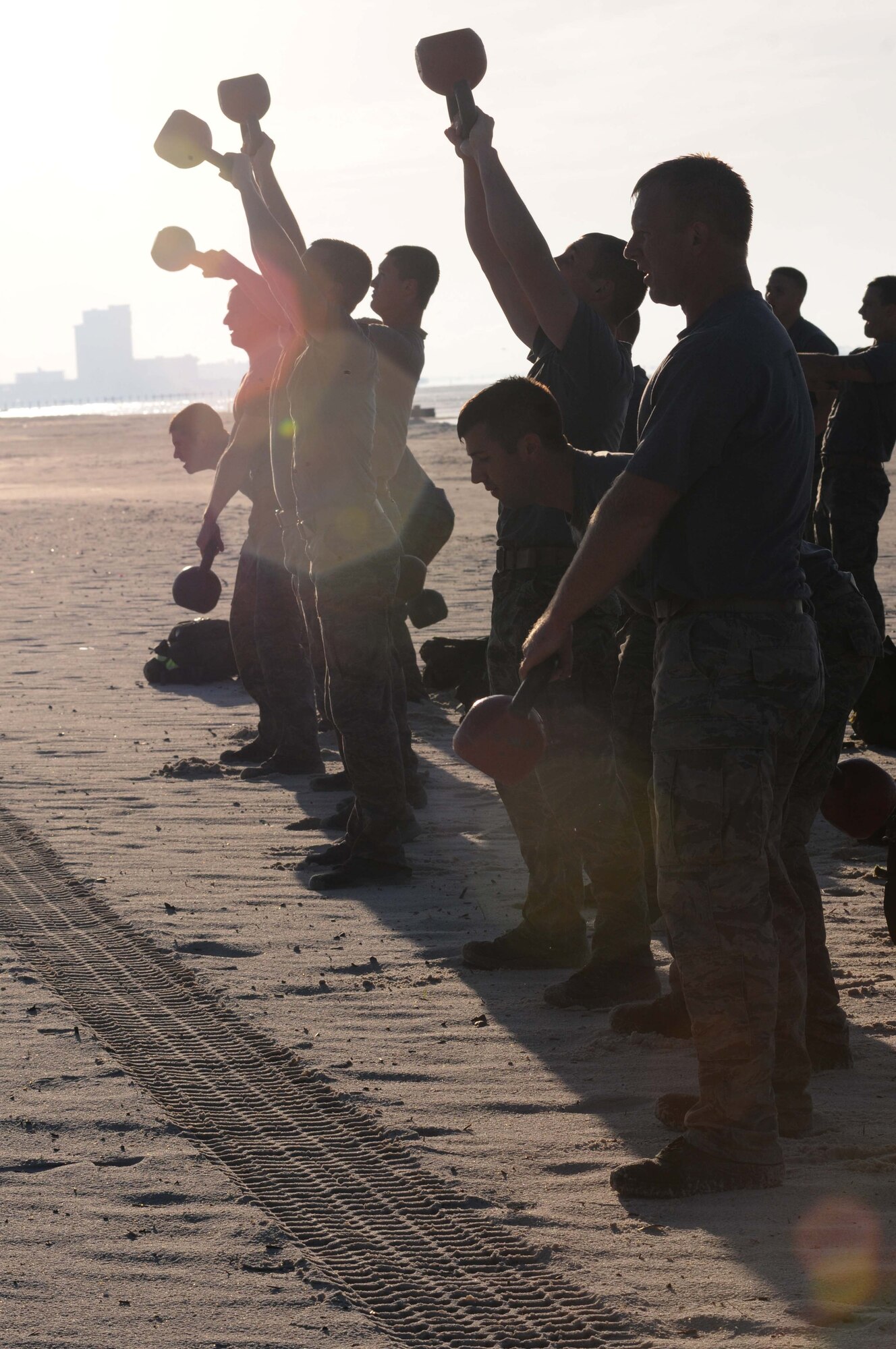 Combat control trainees from the 334th Training Squadron do 100 kettlebell arm snatches during a physical training session April 12, 2013, on Biloxi beach.  Combat controllers are ground troops who are embedded with special forces teams and provide close-air support for special forces units. While at Keesler, trainees learn how to run, swim, carry a rucksack and conduct air traffic control. These Airmen are prepared physically and mentally for the demands of the combat controller pipeline while earning air traffic control certification in just 15 weeks.  (U.S. Air Force photo by Kemberly Groue)