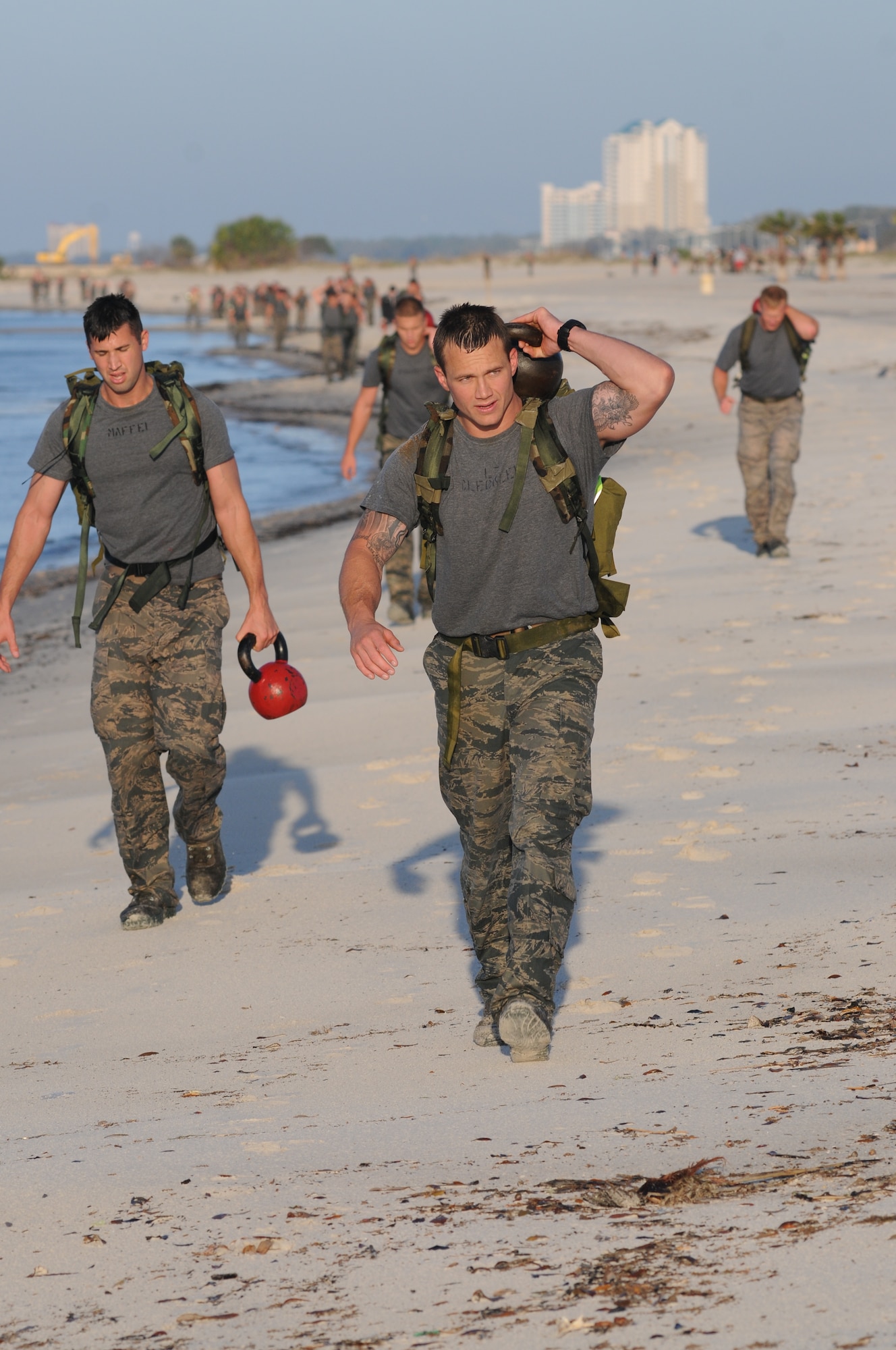 Airman 1st Class Craig Maffei and Second Lt. James Cleckler, 334th Training Squadron, carry kettle bells to their next workout stations during the combat controllers’ physical training session April 12, 2013, on Biloxi beach.  Combat controllers are ground troops who are embedded with special forces teams and provide close-air support for special forces units. While at Keesler, trainees learn how to run, swim, carry a rucksack and conduct air traffic control. These Airmen are prepared physically and mentally for the demands of the combat controller pipeline while earning air traffic control certification in just 15 weeks.  (U.S. Air Force photo by Kemberly Groue)