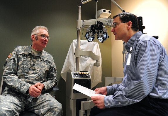 Dr. Allan Rhoads, 92nd Medical Group optometrist, speaks with Sgt. 1st Class James Miller, a recruiter, about his vision before performing a check up at Fairchild Air Force Base, Wash., April 11, 2013. The clinic offers two appointments each day for patients specifically "other than active-duty" beneficiaries. (U.S. Air Force photo by Airman 1st Class Janelle Patiño)