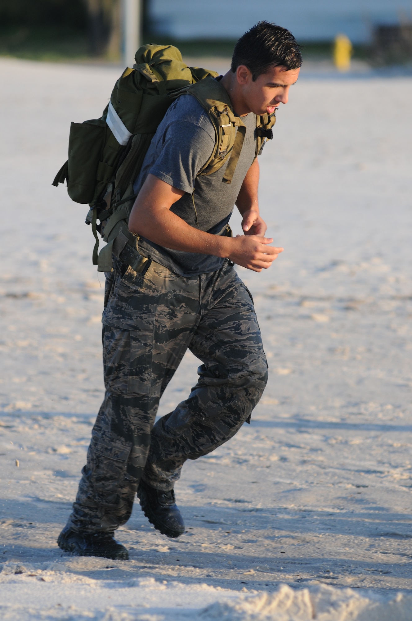Airman 1st Class Christian Ozuna, 334th Training Squadron, runs along the shoreline to the next workout session while carrying a rucksack on his back during the combat controllers’ physical training session April 12, 2013, on Biloxi beach.  Combat controllers are ground troops who are embedded with special forces teams and provide close-air support for special forces units. While at Keesler, trainees learn how to run, swim, carry a rucksack and conduct air traffic control. These Airmen are prepared physically and mentally for the demands of the combat controller pipeline while earning air traffic control certification in just 15 weeks.  (U.S. Air Force photo by Kemberly Groue)
