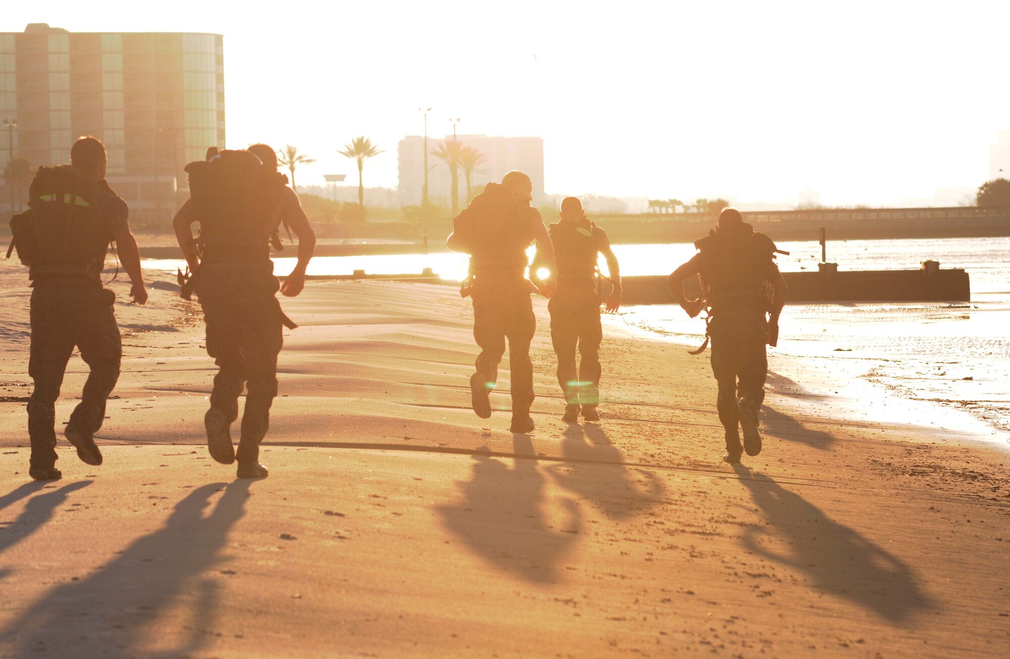 Combat control trainees from the 334th Training Squadron run along the shoreline to the next workout session while carrying ruck sacks on their backs during a physical training session April 12, 2013, on Biloxi beach.  Combat controllers are ground troops who are embedded with special forces teams and provide close-air support for special forces units. While at Keesler, trainees learn how to run, swim, carry a rucksack and conduct air traffic control. These Airmen are prepared physically and mentally for the demands of the combat controller pipeline while earning air traffic control certification in just 15 weeks.  (U.S. Air Force photo by Kemberly Groue)