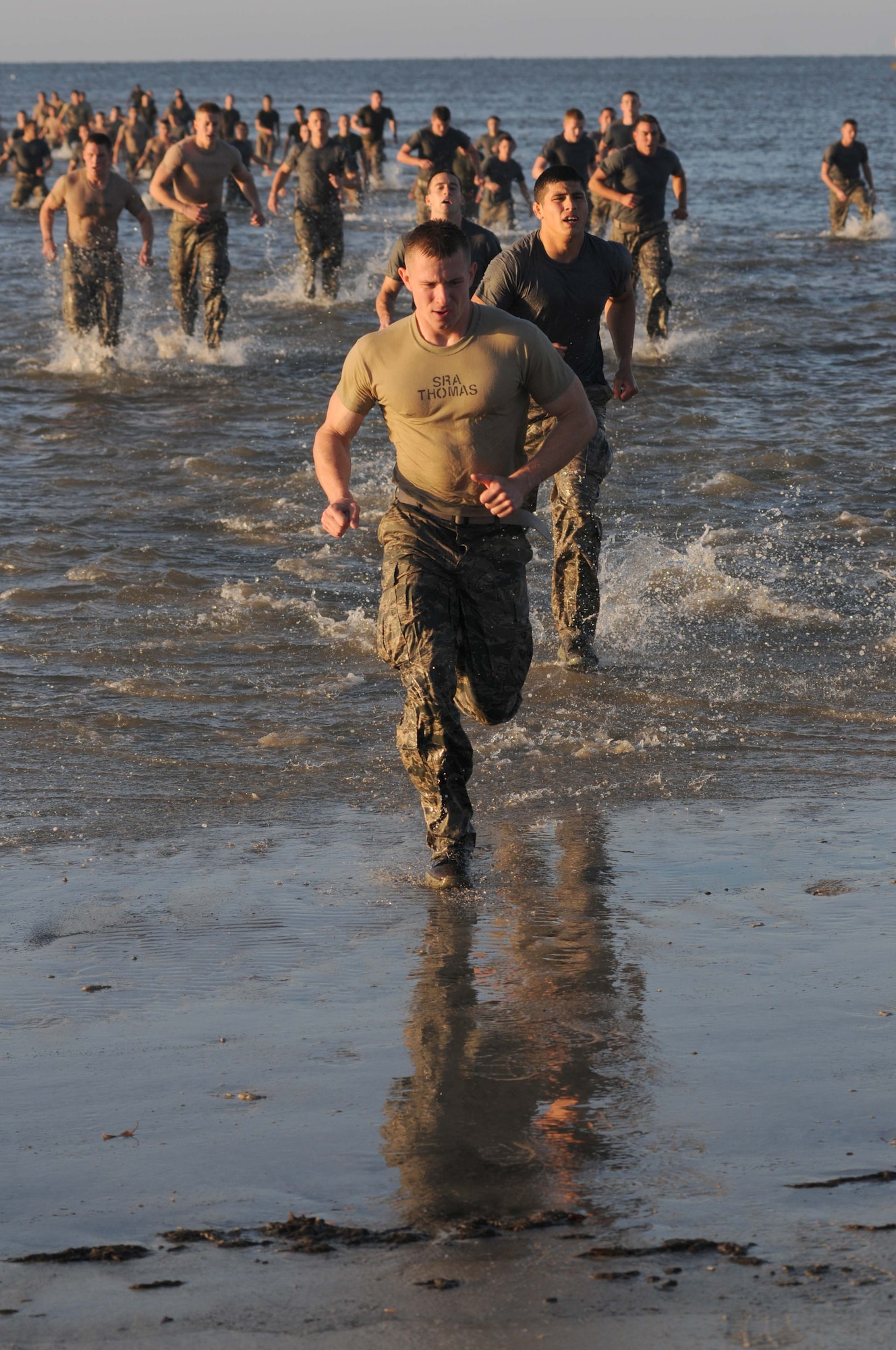 Combat control trainees from the 334th Training Squadron run back on shore after doing 100 jumping jacks in the Gulf of Mexico during a physical training session April 12, 2013, on Biloxi beach.  Combat controllers are ground troops who are embedded with special forces teams and provide close-air support for special forces units. While at Keesler, trainees learn how to run, swim, carry a rucksack and conduct air traffic control. These Airmen are prepared physically and mentally for the demands of the combat controller pipeline while earning air traffic control certification in just 15 weeks.  (U.S. Air Force photo by Kemberly Groue)